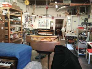 The busy restoration shop at 88 Keys Piano Warehouse